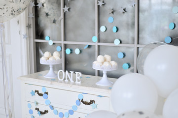Fototapeta na wymiar One year birthday decorations ideas. Decoration for holiday party. A lot of balloons Silver and white colors. Cake for holiday party. 