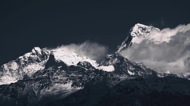 Time-lapse of Dust of snow covered mountain blowing by wind, view from Annapurna Trek in blue tone  