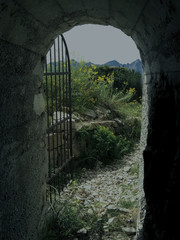 old stone arch with iron gate somewhere in the mountains 