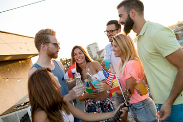Group of happy friends having party on rooftop