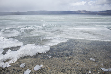 Spring lake with melting ice
