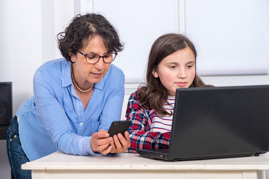 Mom And Daughter Using A Laptop At Home