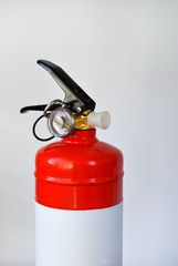 Compact red fire extinguisher for auto or home on white background. For fire emergencies.