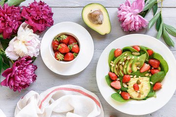 breakfast vegan salad with avocado, strawberries, pine nuts