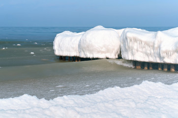 The sea is frozen. Pier in the ice. Sea coast in the ice in the winter. The frozen Baltic Sea.