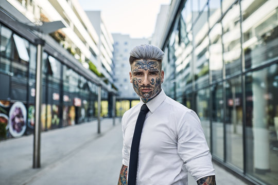 Businessman with tattooed face in city