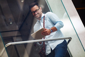 Portrait of businessman in glasses holding tablet