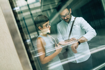 Obraz premium Picture of young businesspeople talking in elevator
