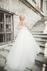 Beautiful luxury young bride in wedding dress posing in park