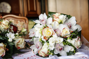 Bellissimo bouquet con rose e orchidee bianche sopra un tavolo dentro una stanza