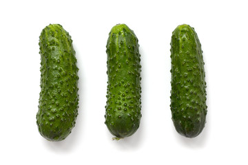 three green cucumbers on a white background