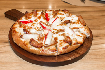 Fast food italian traditional.Hot chicken sausage pizza with cheese, imitation crab stick on wooden board table classic in top view.Closed up.Copy space.