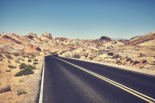 Retro stylized picture of a desert road, travel concept.