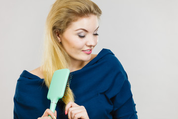 Woman brushing her long hair with brush