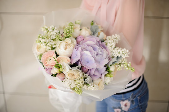 Girl holding a beautiful bouquet of violet tender flowers