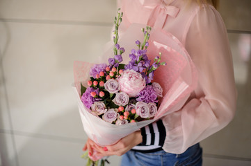 Girl holding a beautiful bouquet of bright violet spring flowers