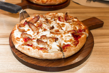 Fast food italian traditional.Hot chicken sausage pizza with cheese, imitation crab stick on wooden board table classic in top view.Closed up.Copy space.