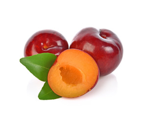 red cherry plum with green leaves isolated on white background