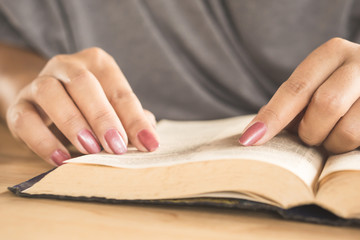 woman hand open book reading on table, education concept background