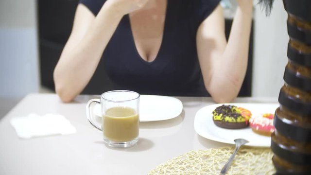 woman is eating pizza in the kitchen at home and using her smartphone, 4k, background blur