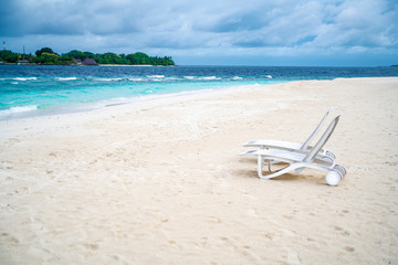 Fototapeta na wymiar Two chaise lounges on the beach