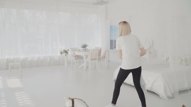 Mother swinging her beautiful daughter in the room. Happy family. Slow motion