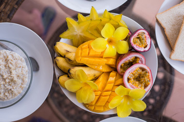 Healthy summer breakfast concept. Colorful fruit smoothie bowl with fresh raw fruits and oat flakes bowls. Top view, horizontal