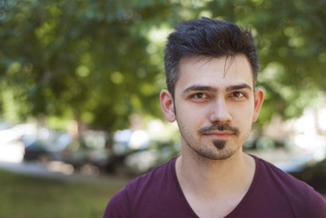 Young Man Portret close Up Smiling Outdoors Portrait with copy space Blurred Park Background