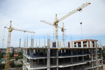 Fototapeta na wymiar A modern new building. Working crane on the construction of the house. Construction site with cranes on sky background. 