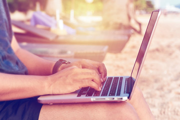 Man with laptop working on a summer day on the beach