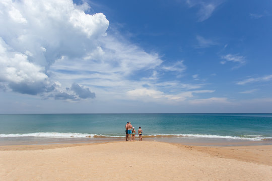 Big family tourist on white sand beach at Mai Khao beach, one of the most popular beaches among tourists in Phuket.
