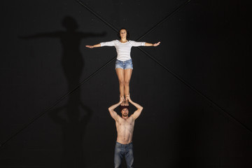 Jóvenes realizando ejercicios de portes acrobáticos en estudio de fotografía