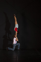 Jóvenes realizando ejercicios de portes acrobáticos en estudio de fotografía