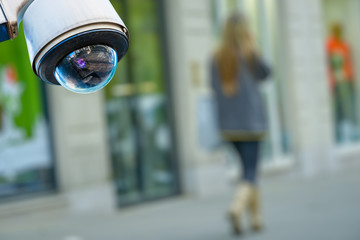 security CCTV camera or surveillance system with a pedestrian on blurry background