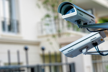 security CCTV camera or surveillance system with private builiding on blurry background