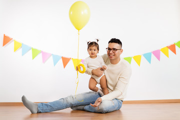 family, holidays and people concept - happy father and little daughter with helium balloon on birthday party