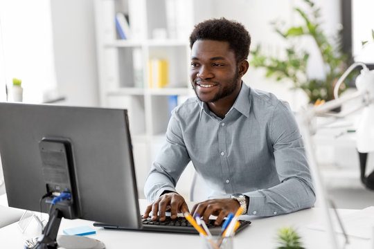 business, people and technology concept - african american businessman with computer working at office