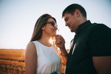 A couple of lovers looking at each other and fooling around.Guy gives flower to girl.Summer day.Couple in love