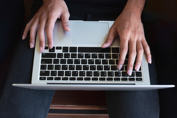 Fototapeta na wymiar Top view of human hands typing on laptop computer