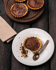 chocolate mini tarts, white plate, wooden board, old wooden table, wooden boar, brown, 