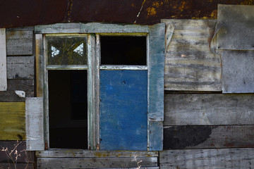 Broken window of an old, abandoned wooden house.