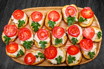Canape with cheese and garlic and tomato .