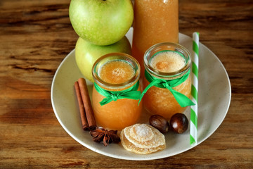 Apple beverage with candied ginger and different spices in glass jars