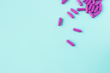 Purple hard gelatin capsules on light blue background