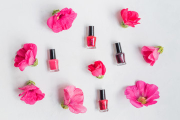 Obraz na płótnie Canvas Flat lay pattern with pink flowers and female cosmetics