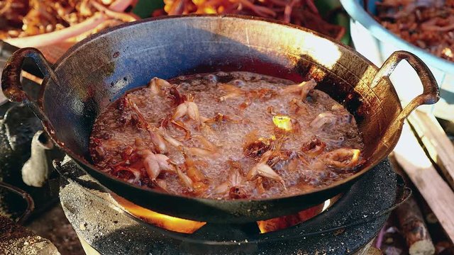 Deep-frying bullfrogs in a wok over a household stove ( close up )
