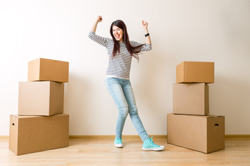Photo of young woman among cardboard boxes