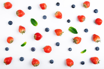 Strawberry, blueberry and mint leaves on white background, top view. Berries pattern, flat lay....