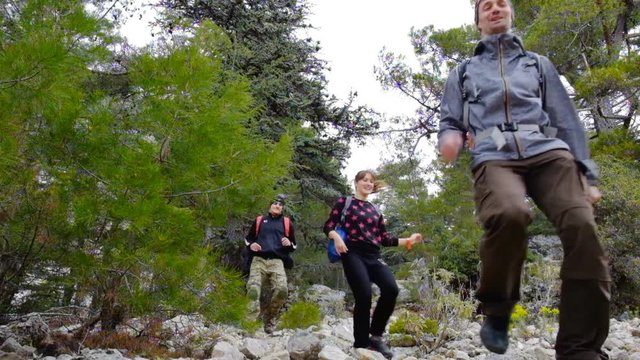 Happy hikers walking outdoors wearing hiker backpacks.