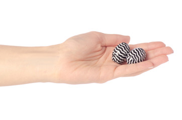 Candy chocolate eggs in a hand on a white background isolation